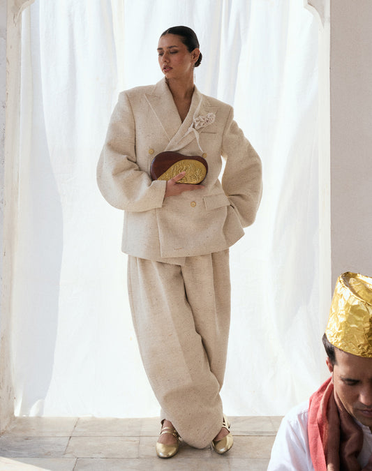 A model holding a luxury Sang bag in carved sheesham wood with brass accents with.