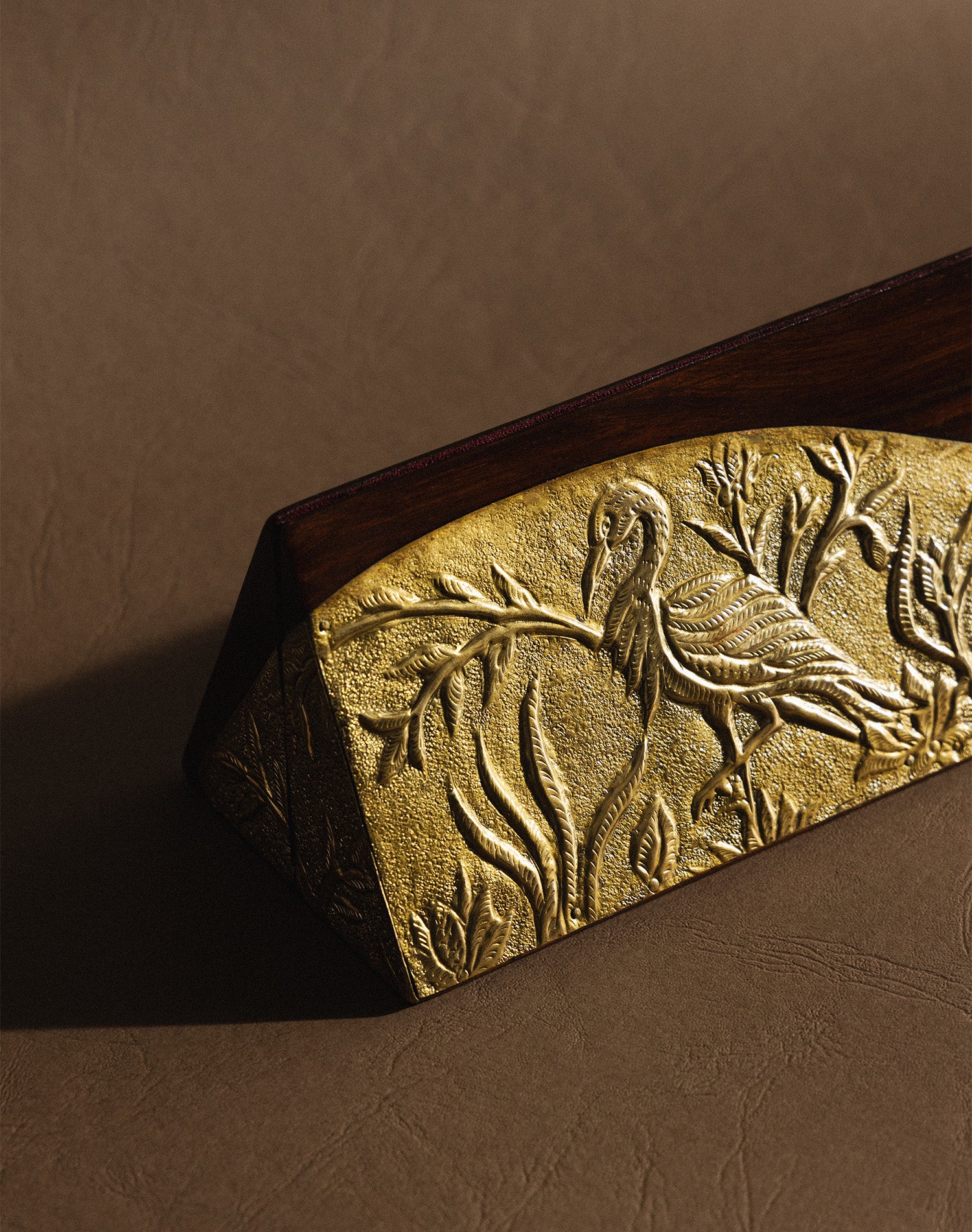 Decorative wooden plaque with bird embossing.
Close-up of Kunj handcrafted brass panel highlighting the intricate brass design.