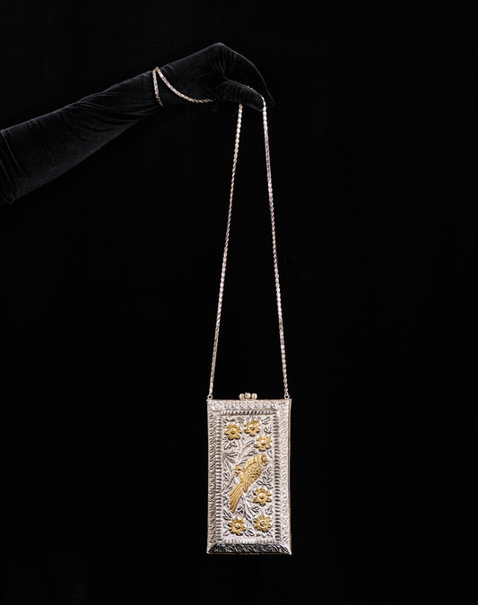 Sandooq Bag: A handcrafted rectangular box clutch made of silver and gold-toned brass with intricate floral engravings.
